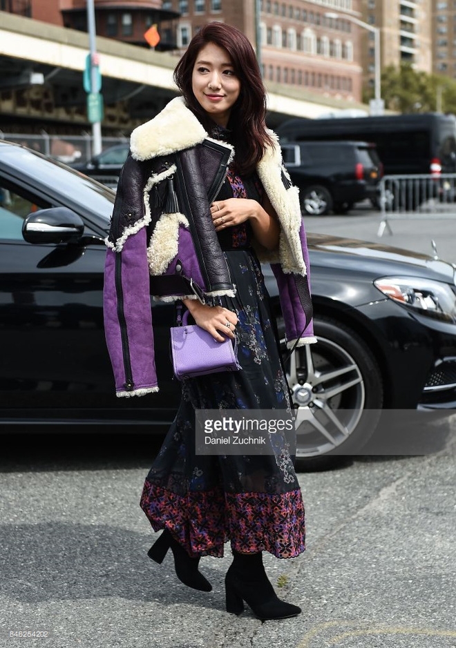 Park Shin Hye chọn phong cách nữ tính với váy liền họa tiết, khoác hững hờ jackets da lộn pha màu của Coach, túi xách xuyệt tông với gam màu tím nền nã.