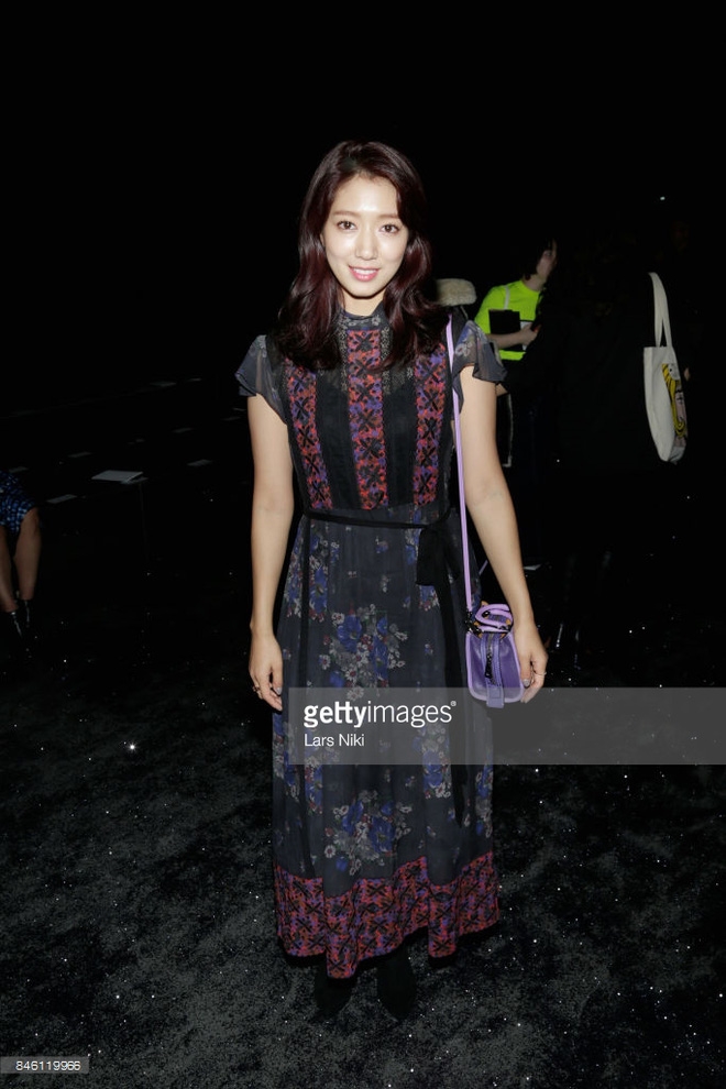 Park Shin Hye chọn phong cách nữ tính với váy liền họa tiết, khoác hững hờ jackets da lộn pha màu của Coach, túi xách xuyệt tông với gam màu tím nền nã.