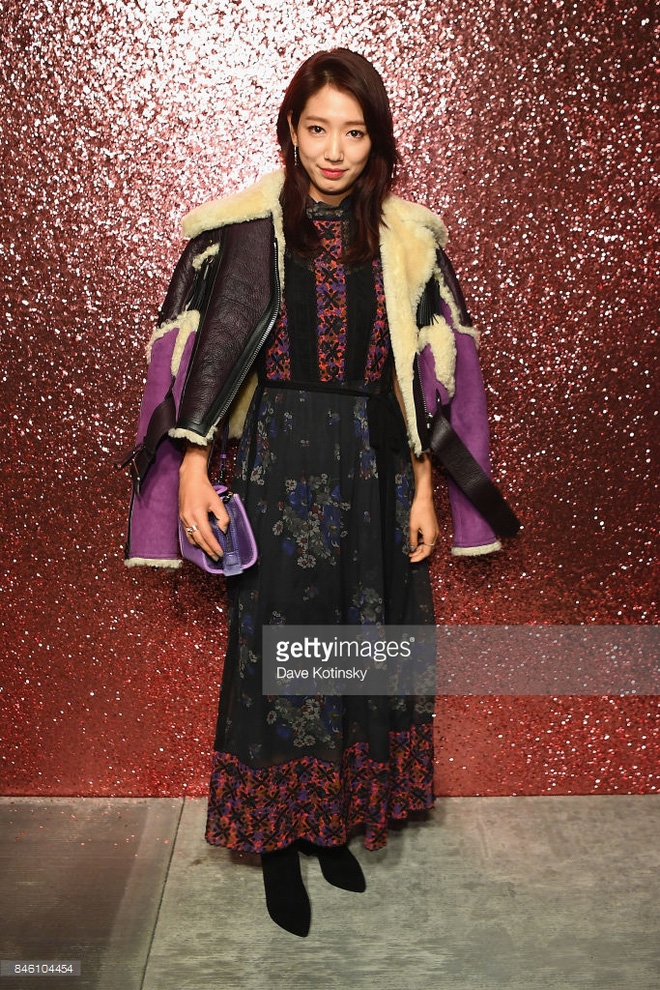 Park Shin Hye chọn phong cách nữ tính với váy liền họa tiết, khoác hững hờ jackets da lộn pha màu của Coach, túi xách xuyệt tông với gam màu tím nền nã.